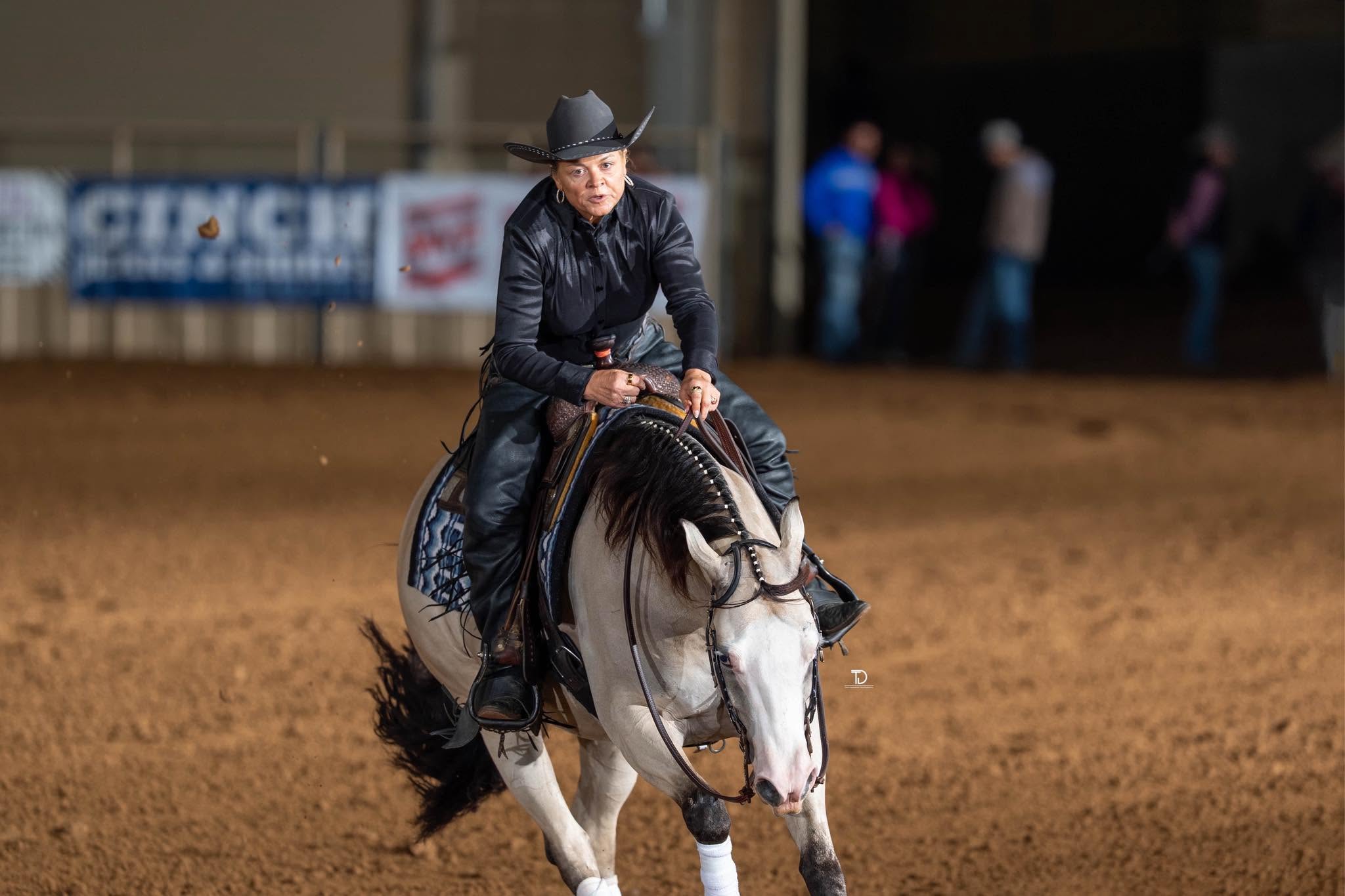 Chardonnay and rider competing in a reining arena